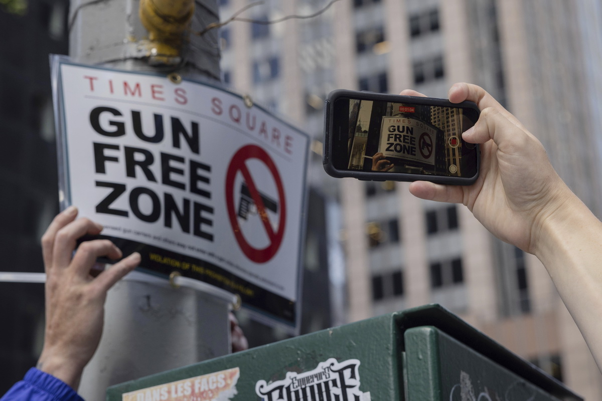 8月31日，在纽约时期广场近邻，人们拍摄确立的“禁枪区”标记牌。