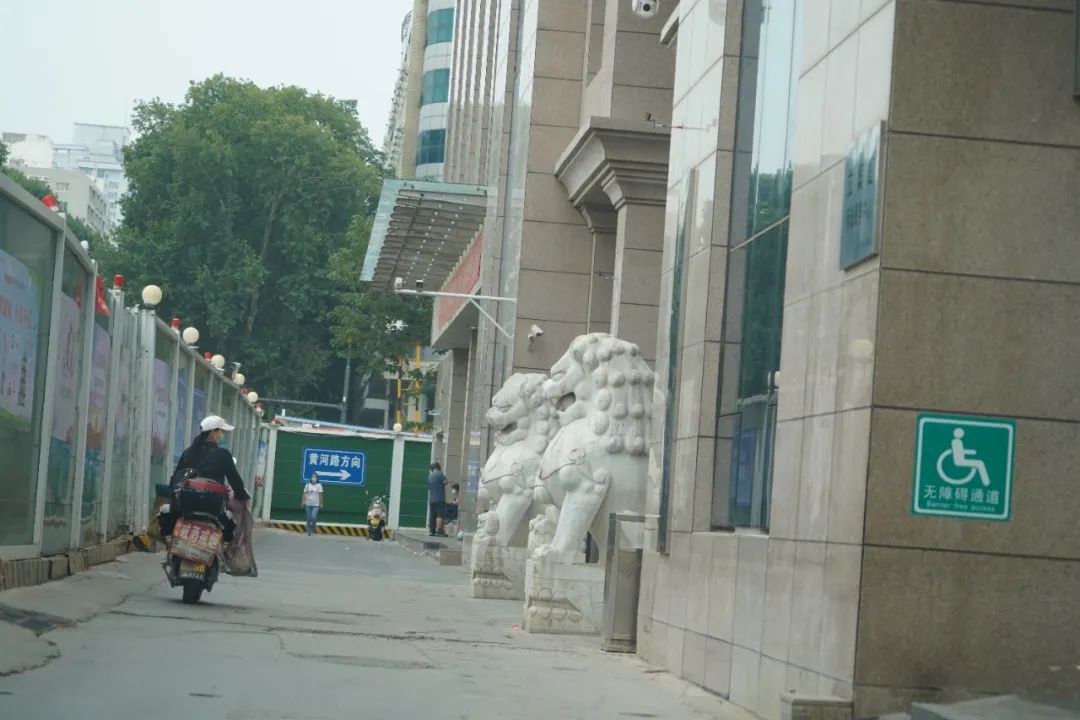 郑州市金水区法院。一名骑车经过的女子向内张望。刘虎 摄