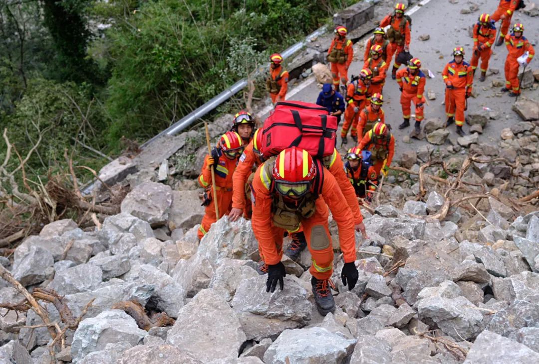 9月6日，在泸定县磨西镇共和村，救援人员徒步进入灾区救援。新华社发（程雪力 摄）