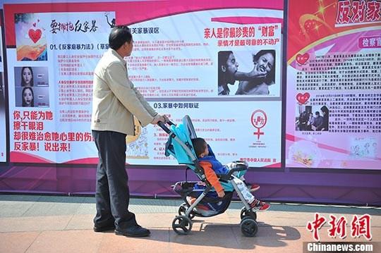资料图:市民在广西南宁市民族广场观看反家暴资料。 中新社记者 胡雁 摄