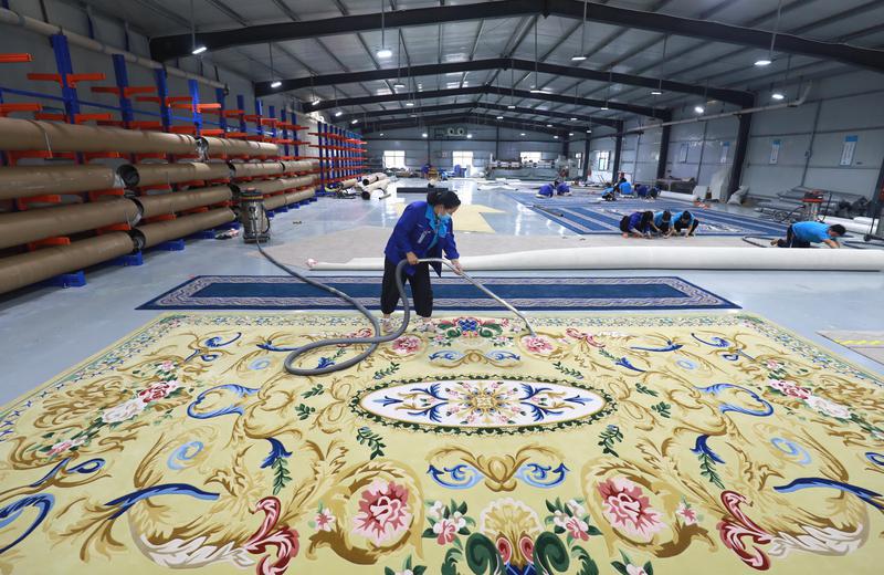 ▲8月17日，工人在河北省石家庄市行唐县一家外贸地毯生产企业清理地毯产品。图/新华社