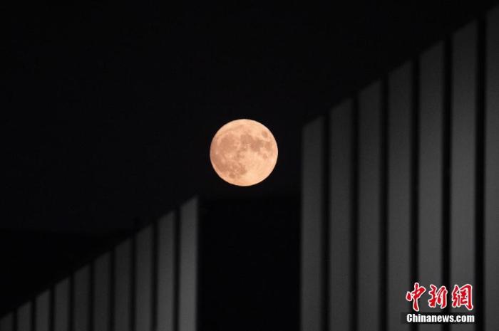 资料图：农历八月十五中秋节，圆月与北京的现代建筑相映成趣。 中新社记者 盛佳鹏 摄
