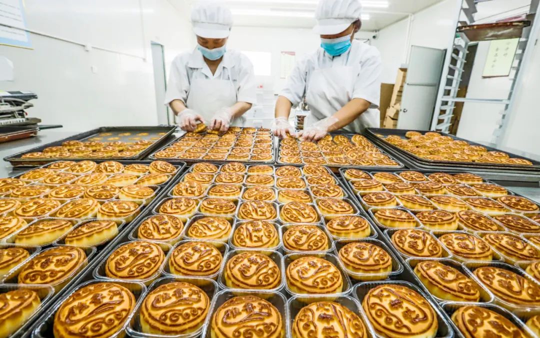 中秋节前夕，月饼生产企业里的工人们正在加班加点赶制月饼，满足节日期间市场需求。图/新华社