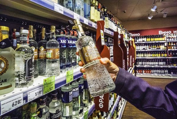 资料图片：一名消费者在俄罗斯符拉迪沃斯托克“桑百利”超市购买伏特加。（新华社）
