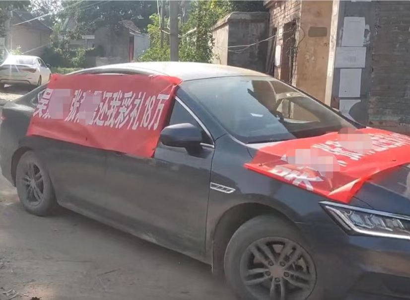 小伙驱车挂横幅进村声讨  视频截图
