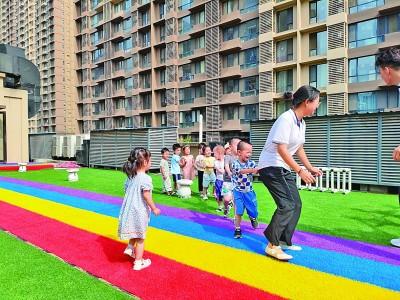 在西安某托育中心,孩子们在玩“老鹰捉小鸡”的游戏。光明图片