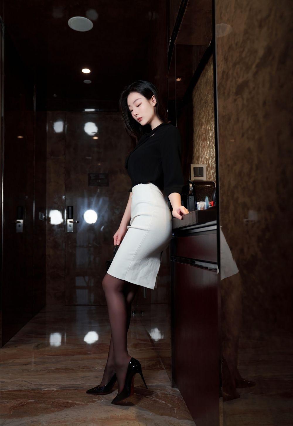 及膝的长度刚刚好,露出的腿部线条用一双黑色的丝袜修饰,纤细又高挑