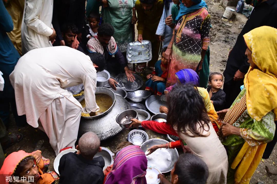 当地时间2022年8月28日，巴基斯坦登多穆罕默德汗，灾民因洪水而流离失所，他们正在领取食物。