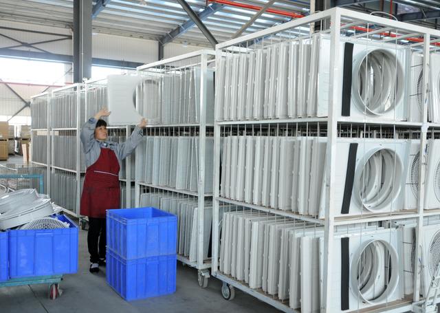Một nhân viên phân loại các bộ phận điều hòa không khí để xuất khẩu tại một nhà máy ở Cửu Giang, tỉnh Giang Tây.  Ảnh từ China Daily