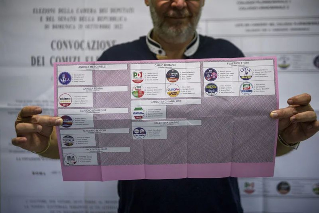 当地时间2022年9月24日，意大利罗马，一名投票站工作人员正在展示意大利议会选举选票。图/视觉中国