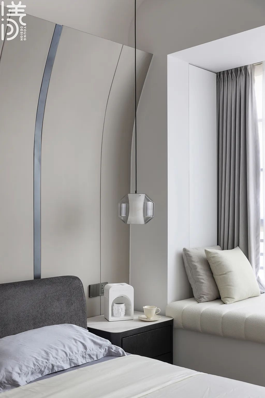 床头墙以弧形的硬包材质,做出一种现代优雅的背景墙造型,两侧分别