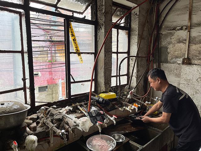 顺昌路560弄小区，水池边装了10多个水龙头，住户在清洗锅具。澎湃新闻记者 李菁 摄