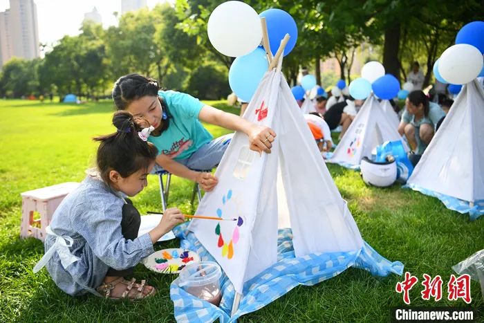 2022年7月31日，山西太原，家长与孩子共同绘制帐篷涂鸦，享受夏日假期时光。中新社记者 武俊杰 摄　