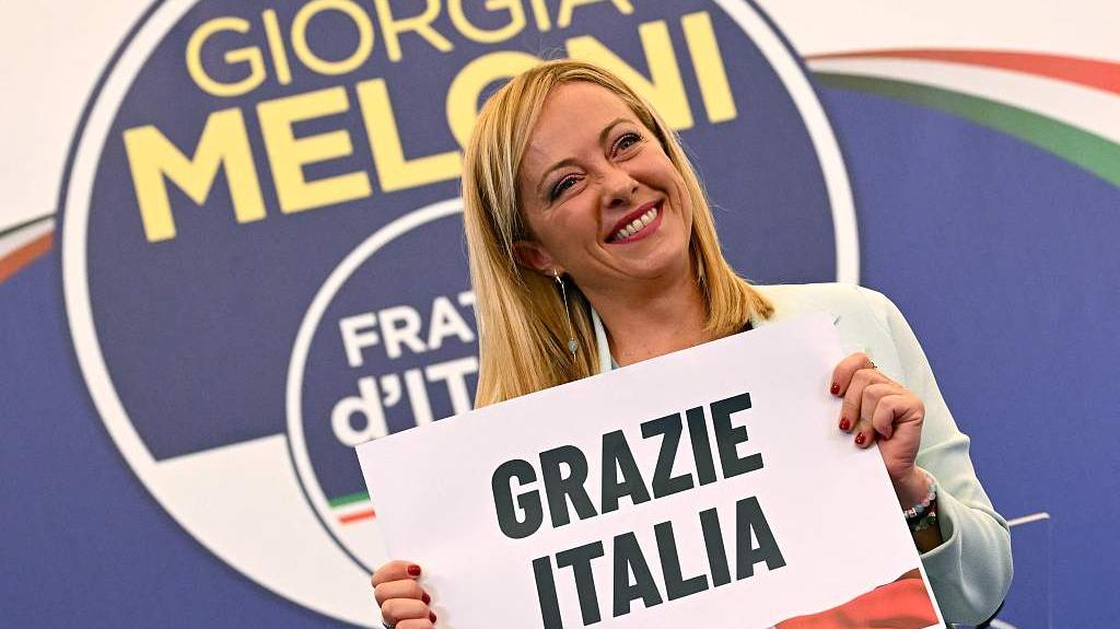  当地时间2022年9月26日，意大利罗马，意大利议会选举投票结束后，意大利极右翼政党“意大利兄弟党”党首梅洛尼在该党竞选总部连夜发表演讲后，手持写有“感谢意大利”的标语牌。 视觉中国 图