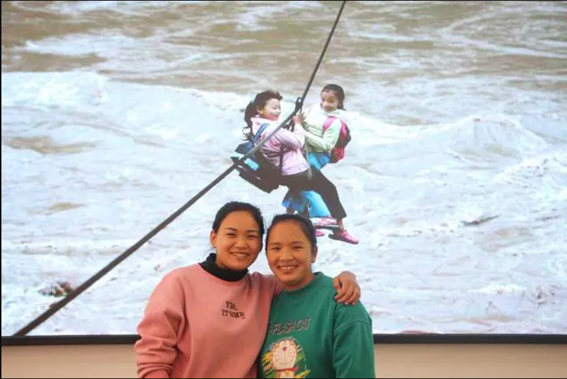 2022年4月26日，余春花（左）和余才妹（右）一起重温姐妹俩当年过溜索时的照片。杨筱涵 摄
