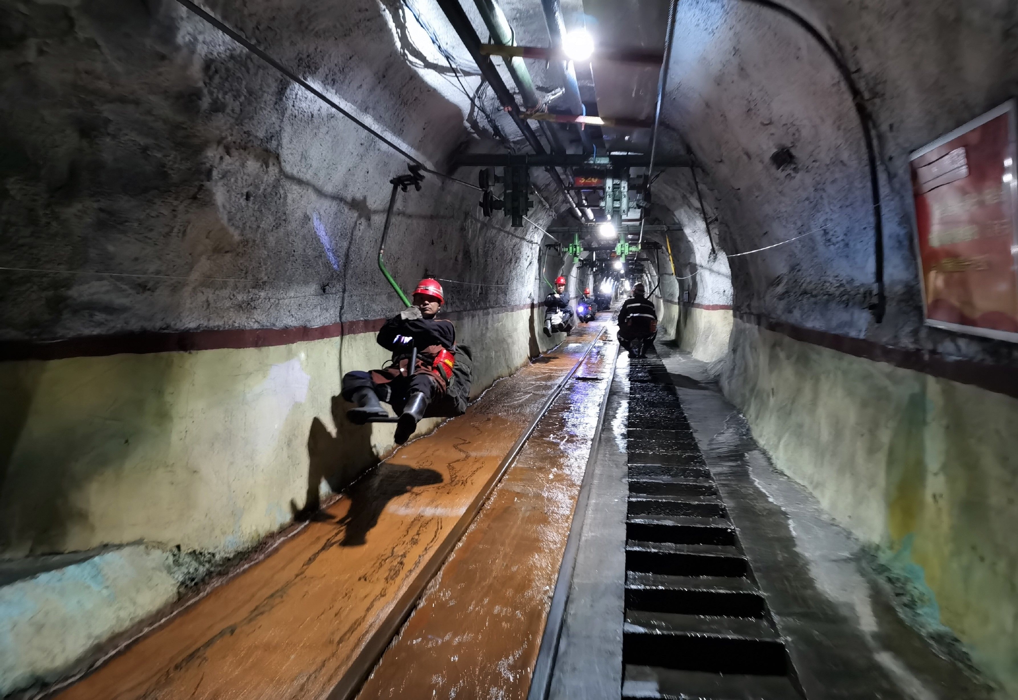 图为送餐员乘坐"猴车"为井下送午餐.
