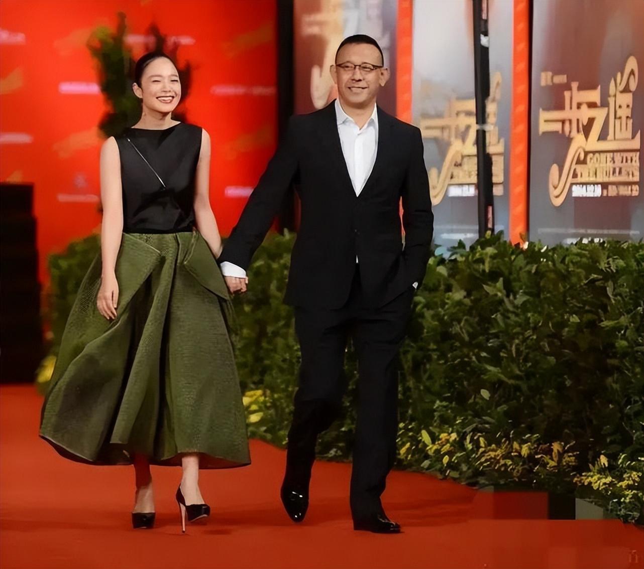 姜文老婆太好看了！周韵穿礼服裙高贵灵气，夫妻俩全程搂腰牵手休闲区蓝鸢梦想 - Www.slyday.coM