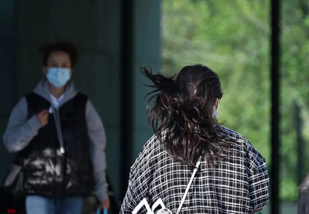 天宫院,路人头发被风吹乱,非机动车上也装上了防风装备.