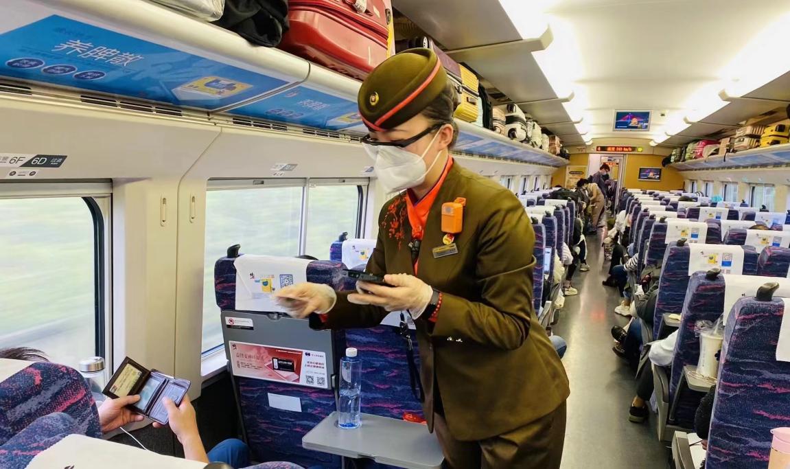 武汉客运段汉口动车组乘务车间列车员在高铁上服务旅客出行.
