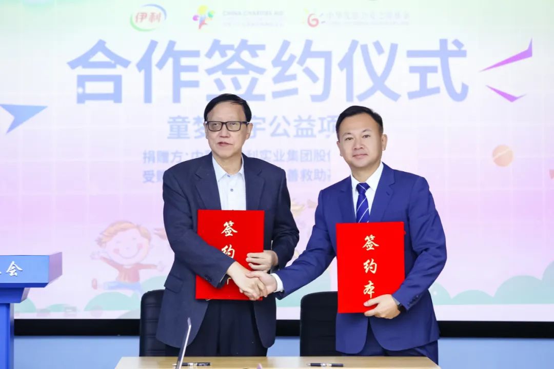 副总裁张轶鹏(右)与中华少年儿童慈善救助基金会理事长王林握手签约