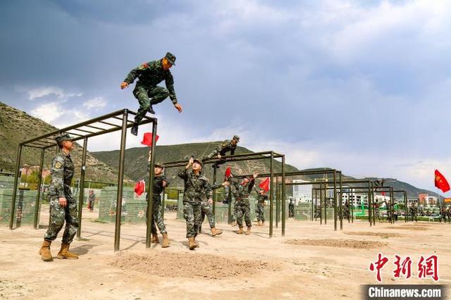 图为参赛选手四百米障碍中越过云梯. 罗元凯 摄