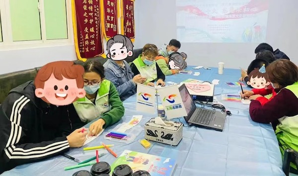 教小朋友们用手中的画笔涂色  咖啡杯套文化创意活动传递“捧在手心里的温暖”休闲区蓝鸢梦想 - Www.slyday.coM