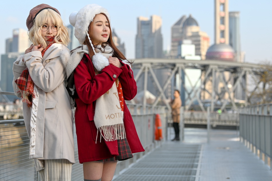 2021年12月17日，两位穿着时髦的女生在河边拍照。澎湃新闻记者 朱伟辉 资料图