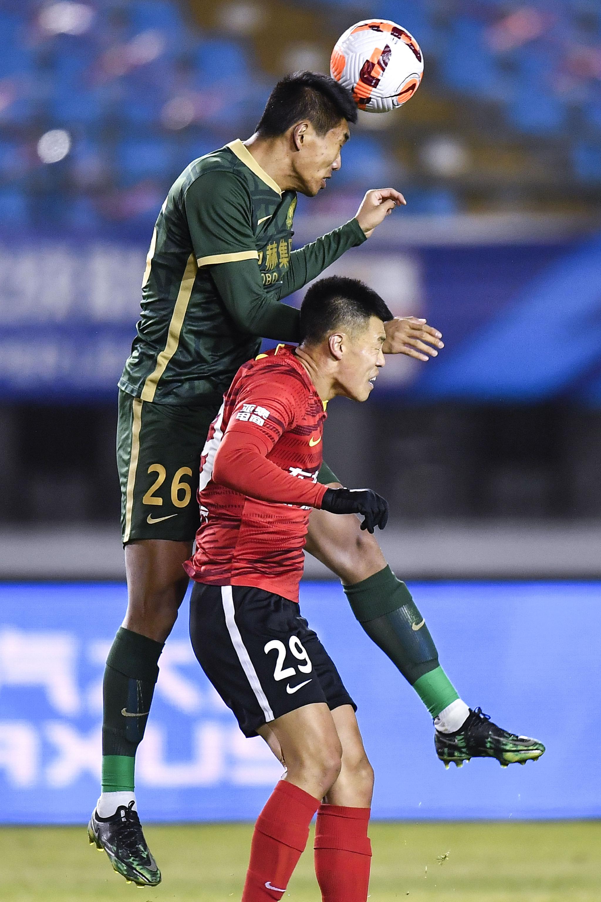 10月24日,北京国安队球员柏杨(上)在比赛中与长春亚泰队球员谭龙争顶.