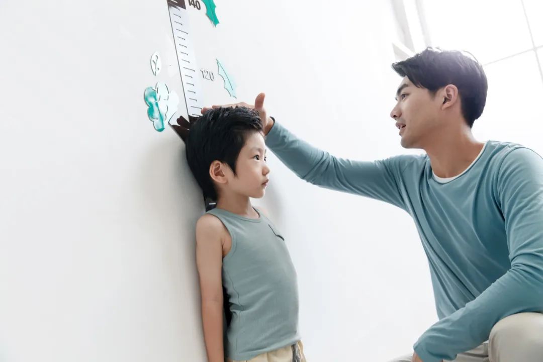 爸爸在为小男孩测量身高.图/ic photo