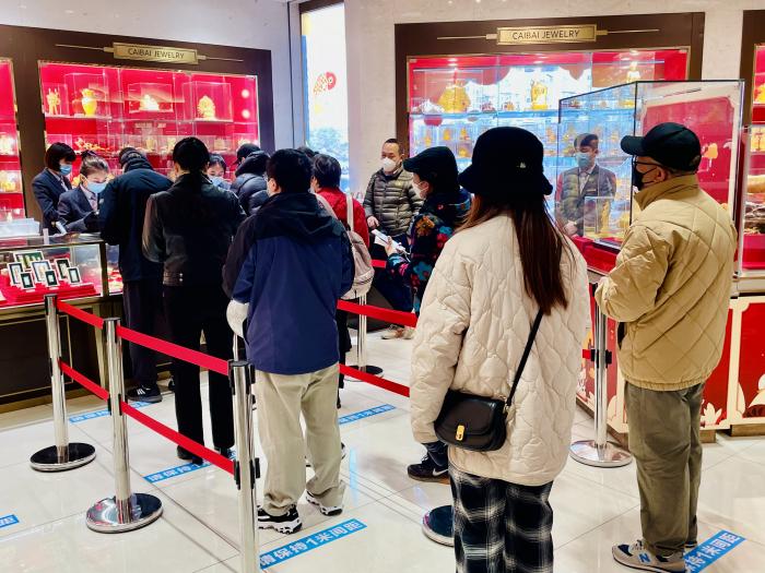 (图片说明:北京市民在菜市口百货排队抢购兔年贺岁金条)