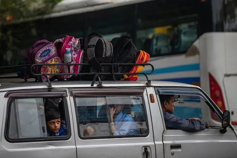 当地时间2022年11月15日,印度新德里,一辆面包车里的学生.
