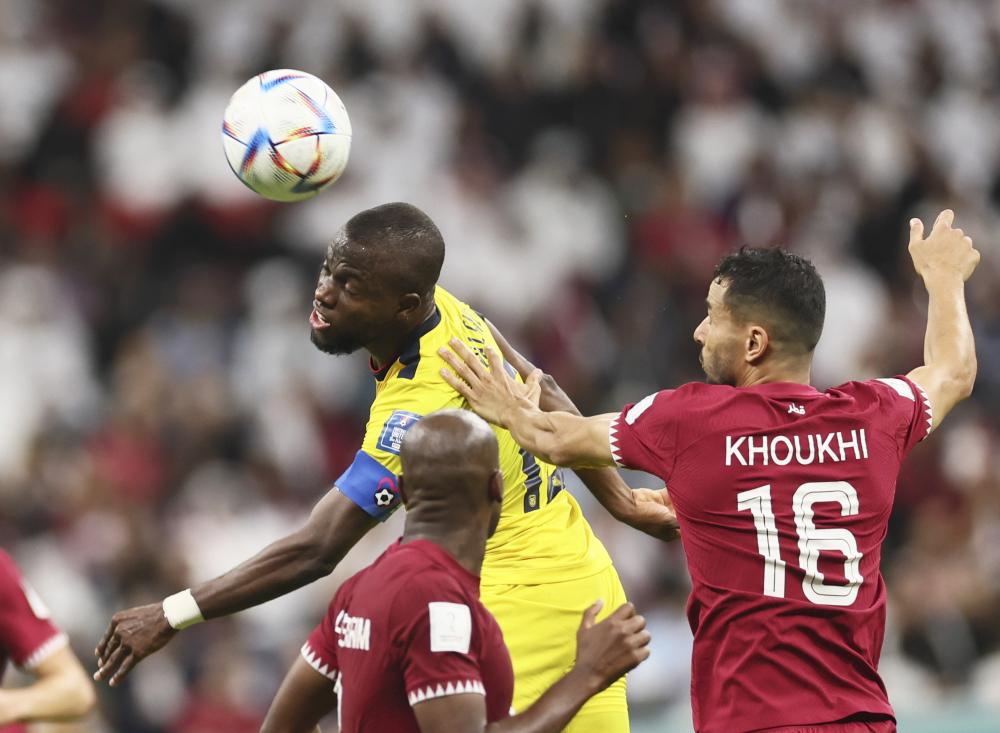 11月20日,厄瓜多尔队球员恩纳·瓦伦西亚(上)与卡塔尔队球员布阿莱姆