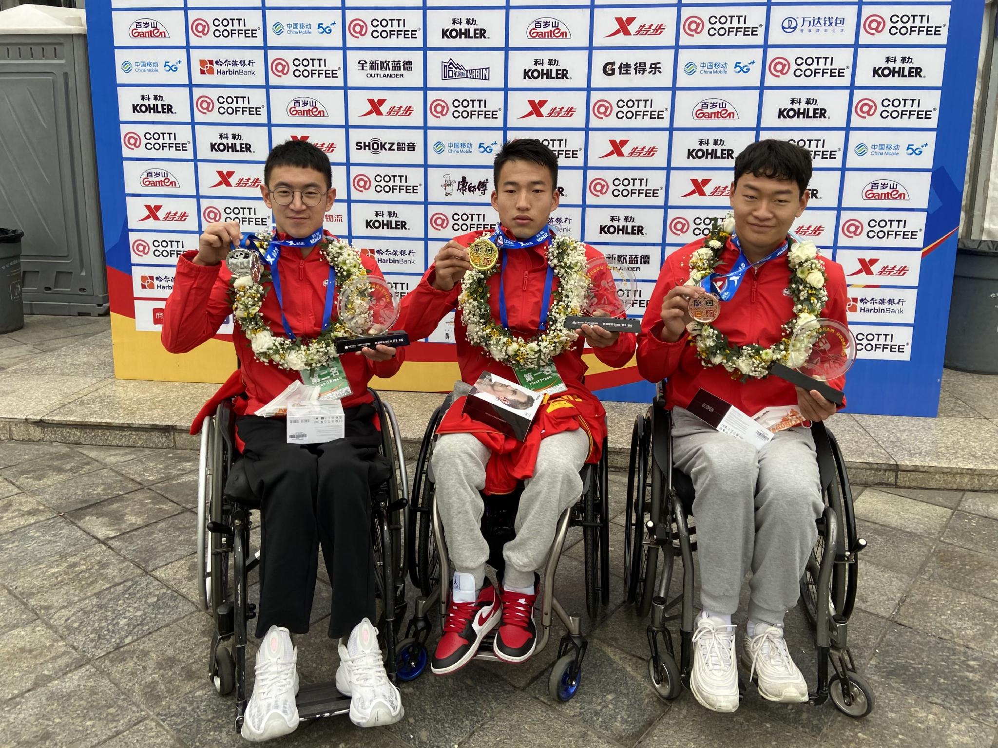 2022成都马拉松轮椅竞速赛男子前三名,从左到右依次为薛浩男、马卓、罗兴传。