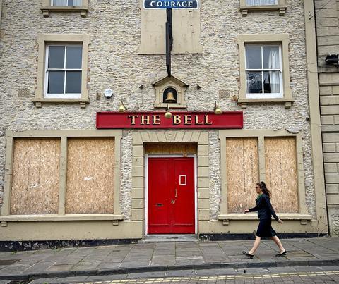 今年7月25日，英国萨默塞特郡一家酒吧停止对外营业，窗户被用木板封上。（资料图）
