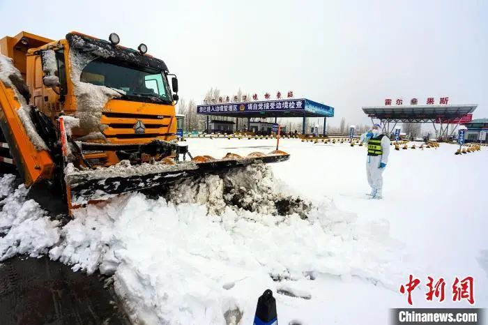 新疆伊犁州八十间房子边境检查站移民管理警察正在指挥扫雪车进行清理道路积雪。周航生 摄