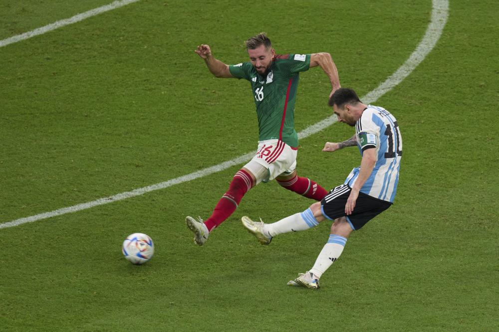 11月26日，阿根廷队球员梅西（右）和墨西哥队球员埃克托尔·埃雷拉在比赛中拼抢。 新华社记者 孟鼎博 摄