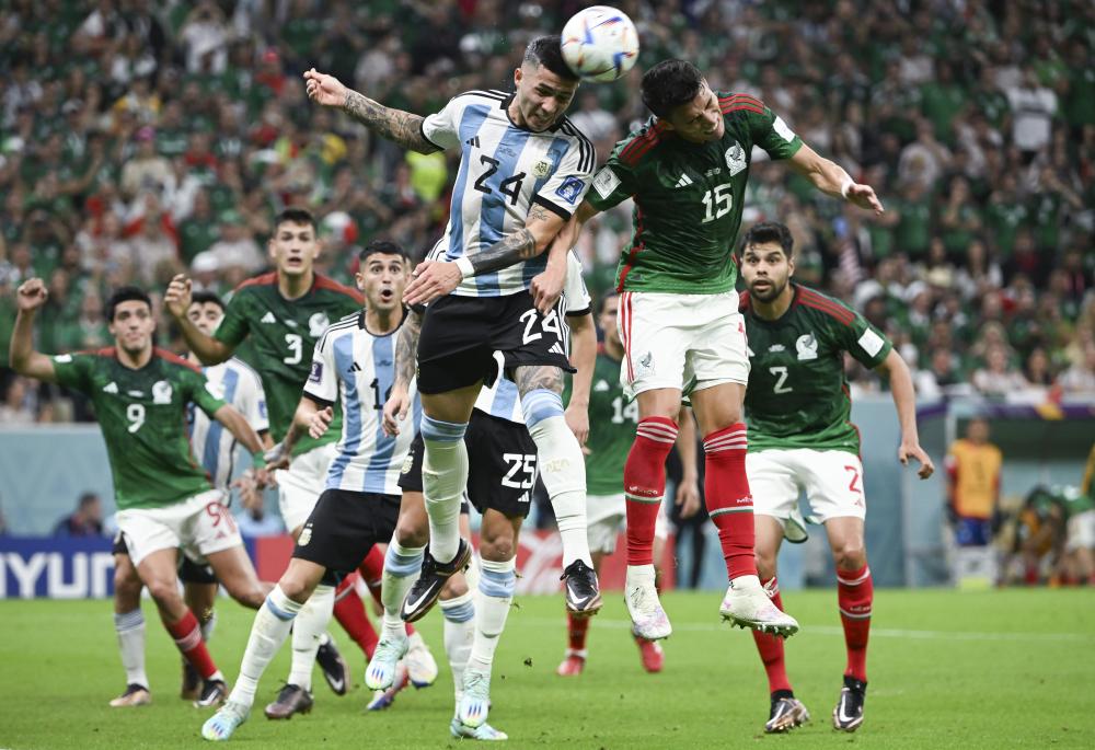 11月26日，阿根廷队球员恩佐·费尔南德斯（前左）和墨西哥队球员埃克托尔·莫雷诺（前右）在比赛中争顶。 新华社记者 李尕 摄