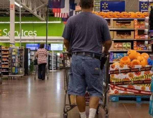 2022年8月31日，在美国得克萨斯州普莱诺市，一名男子随身携带枪支逛超市。图源：新华社
