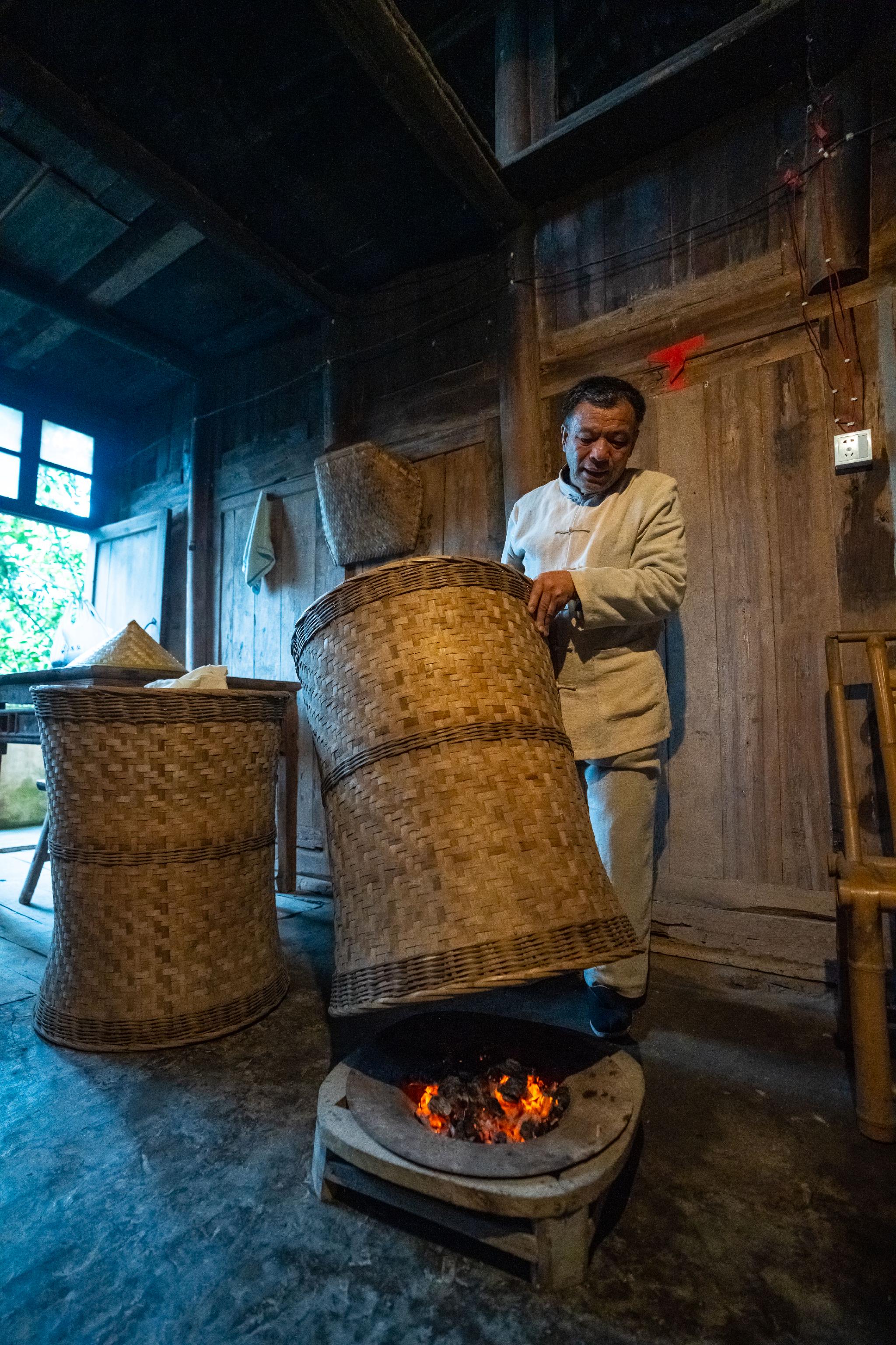 在四川省雅安市名山区的张氏祖屋,张跃华用传统方式烘焙茶叶(2022年3