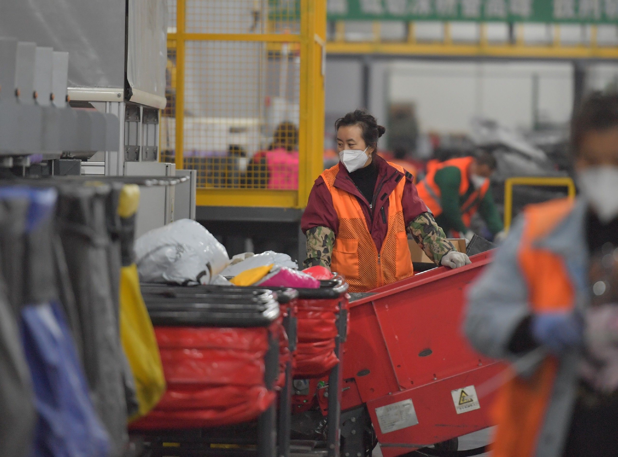 工作人员正在配合智能分拣设备对快递进行分拣.ic 资料图