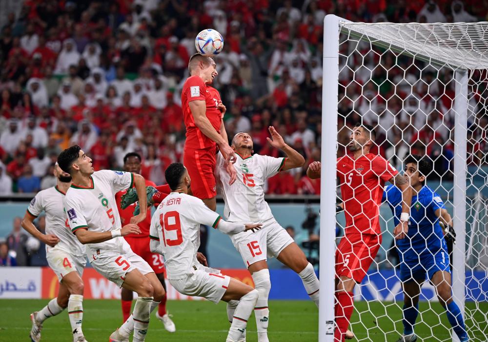 12月1日,加拿大队球员阿里斯塔尔·约翰斯顿(上)在比赛中头球攻门.