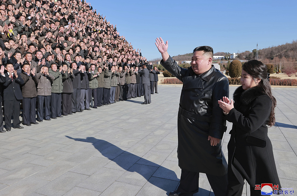 当地时间2022年11月27日，朝鲜领导人金正恩（中）和他的女儿（右）向参与“火星-17”洲际弹道导弹试射的科学家、技术人员、官员和其他工作人员挥手致意。人民视觉 图