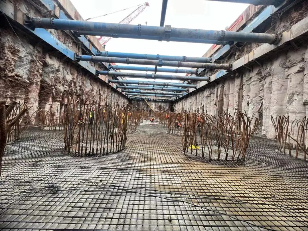 工人们在挖掘机,推土机的协助下,进行着挡土板和锚索施工