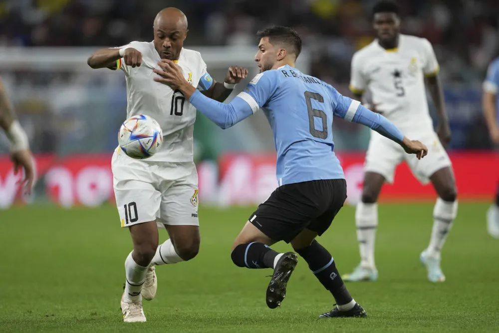 ▲12月2日，加纳队球员阿尤（左）与乌拉圭队球员本坦库尔在比赛中拼抢。新华社记者 郑焕松 摄