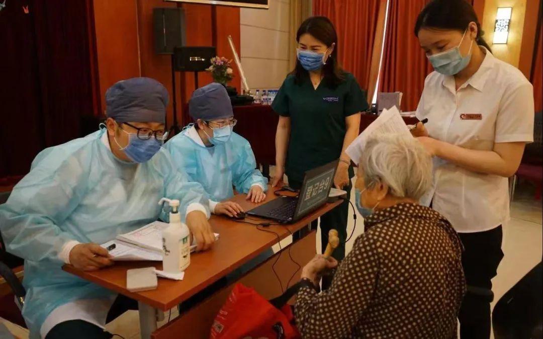 ▲在北京某养老院,医护人员为老人做新冠疫苗接种前的信息登记。新京报资料图