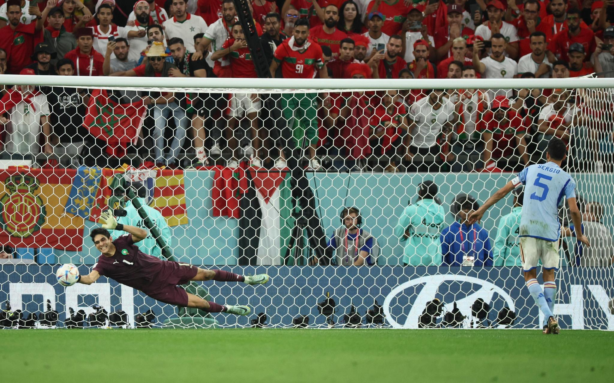 摩洛哥守门员布努(左)在点球大战中扑出西班牙老将布斯克茨的射门.