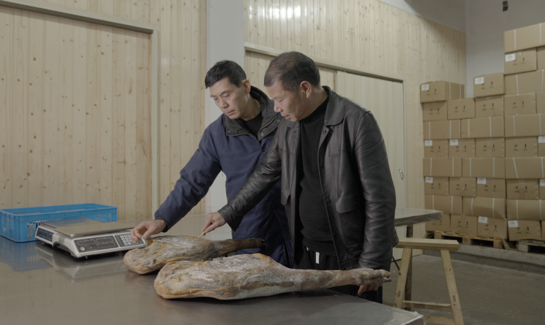 滕维洪（右）自19岁起学习火腿制作，从事相关行业三十余年。