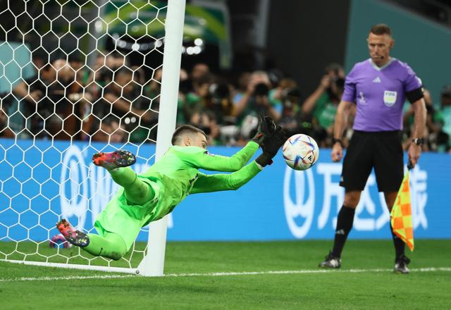 队守门员利瓦科维奇(左)在点球大战中扑出巴西队球员罗德里戈的射门