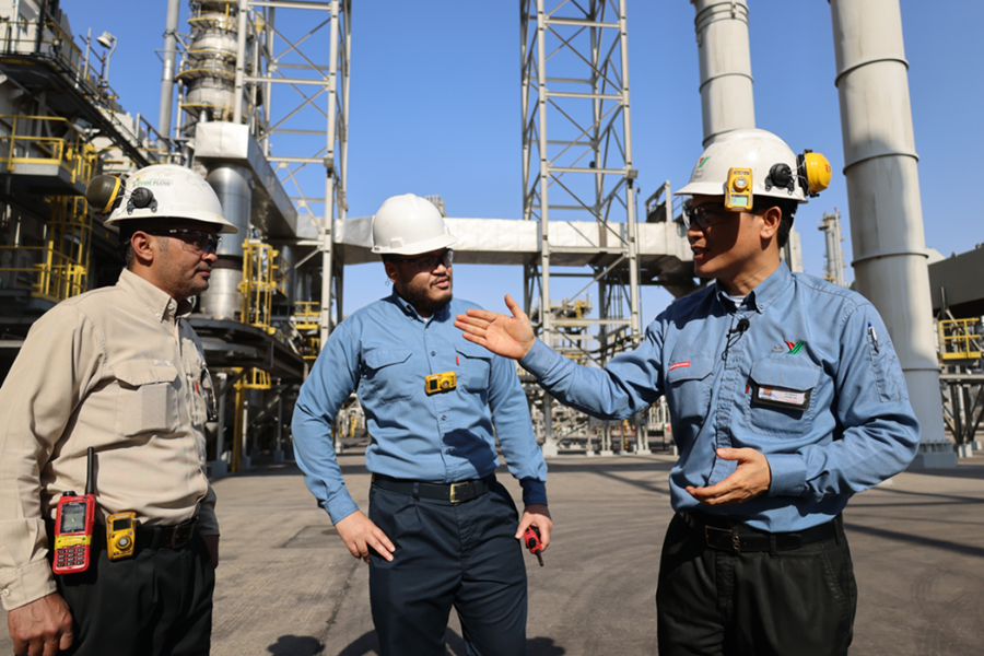 2022年11月27日，在沙特西部城市延布，中沙延布炼厂的员工在交流。总投资86亿美元的中沙延布炼厂是中国石化与沙特阿拉伯石油公司合资兴建的项目，自2016年1月20日由两国元首共同启动投产以来，发展迅速。今年1月至8月累计实现利润11.5亿美元。