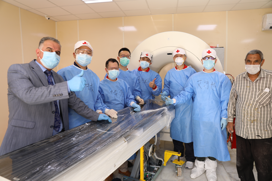 2020年4月12日，在伊拉克首都巴格达，援助伊拉克防治新冠肺炎的中国医疗专家将CT设备搬运到机房后与伊方人员合影。